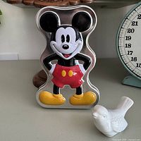 Front view of embossed Mickey Mouse tin showing colored lid details