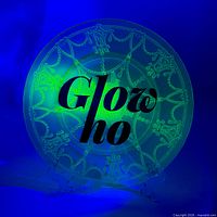 Plate on stand under UV light showing chain and swag pattern and green fluorescence