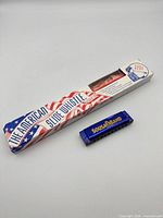 Harmonica beside boxed slide whistle