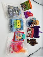 Group shot showing all eight items including sealed bags and loose toys