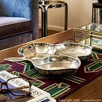 Lifestyle view showing silver-tone cloverleaf dish on a coffee table