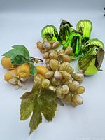 Group shot of six green pear ornaments, grape cluster, lemon cluster with leaves and blossoms