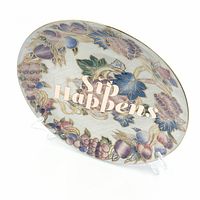 Front angled view of plate showing grapevine design and text