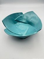 top angled view of turquoise folded ceramic bowl