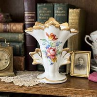 Front view of porcelain bud vase showing floral painting and gold trim