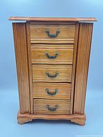Front view of wooden jewelry box showing drawers and hardware