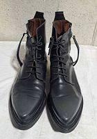 Front view of both boots showing laces, toe shape and leather condition