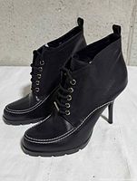 Pair of boots side view showing lace-up design, stitching, heel