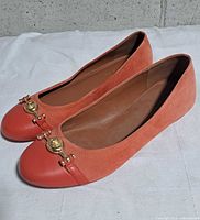 Side view of both flats showing suede body, leather toe cap, hardware