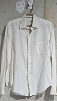 front view of white linen shirt on hanger
