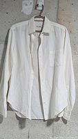 Front view of white linen shirt on hanger
