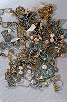 Overall view of tangled fashion jewellery pile with chains, beads, charms and pendants visible