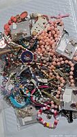 Pile of assorted fashion jewellery pieces including bracelets, necklaces, earrings, some in packaging