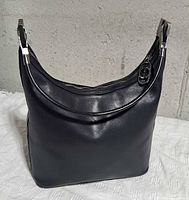 Front view of black leather Gucci shoulder bag showing overall shape and leather condition
