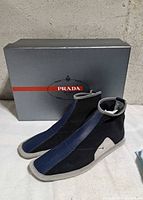 Shoes with original Prada box, three-quarter view