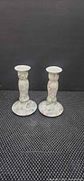 Front view of both porcelain candlesticks