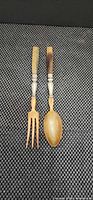 Front view of horn handle serving spoon and fork side by side