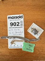 Overview showing gold chain, silver bracelet, turtle charm and lot tag
