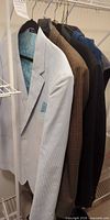 Four sport coats hanging on rack