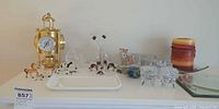 Shelf with entire lot including brass clock, figurines, glassware, candle