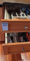 Two open kitchen drawers showing assortment of utensils