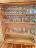 Cabinet shelf showing multiple sizes of inverted stemware
