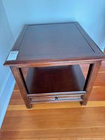 Top view of dark brown wooden end table showing rectangular surface and drawer front