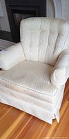 Front view of cream patterned swivel rocking armchair