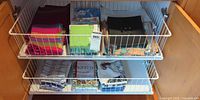 Drawer with two shelves of assorted fabric and packaged paper napkins
