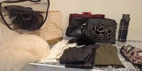 Overall lot on shelf showing hats, gloves, purses, umbrella, mask