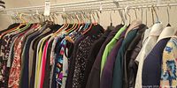 Full rack of assorted women’s dresses and jackets on hangers