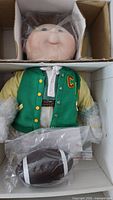 Doll in box with football beneath