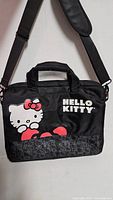 Front view showing Hello Kitty graphic, logo, handles, shoulder strap