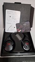 Headset in original open box showing earcups, mic, inserts