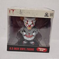 Front view of boxed Pennywise vinyl figure showing branding and size