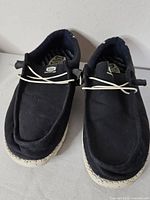 Top view of both Hey Dude sneakers showing laces and canvas uppers