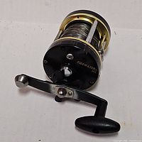 Front angled view of reel showing handle, frame and spool