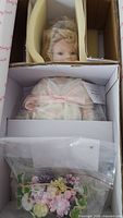 Doll head, bouquet and packaging contents inside box