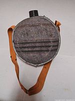 Front view of round Mirro aluminum canteen with felt cover and orange strap