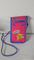 Front view of pink Pokémon Pikachu Game Boy Color case with strap