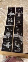 Four black lacquer seashell inlay panels laid out together