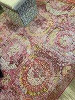 Overview of entire pink patterned area rug on floor