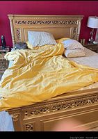 Front view of gold solid wood king size bed frame showing ornate carved headboard and footboard