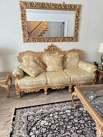 Front view of carved solid wood sofa with yellow patterned upholstery and cushions
