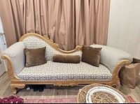 Full view of the sofa showing carved gold frame, patterned upholstery and included cushions