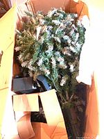 Tree sections, branches and stand inside original cardboard box