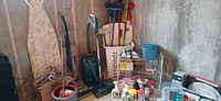 Overall view of lot with vacuums, ironing board, mop bucket, rack and cleaning items