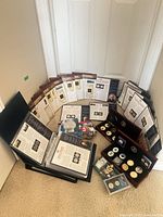 Overview of binders, display cases and coin sets arranged on floor