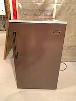 Front view of brown Coldspot bar fridge with handle and logo