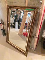 Full view of rectangular mirror leaning against wall